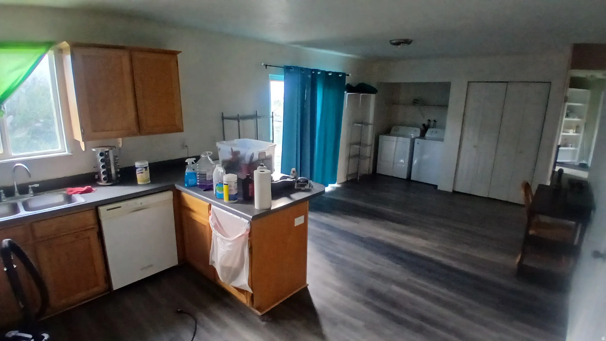 Kitchen area featuring wood-finish flooring, wood cabinetry, and a built-in dishwasher