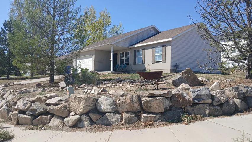 Ranch-style exterior with a covered porch, attached garage, and decorative window shutters