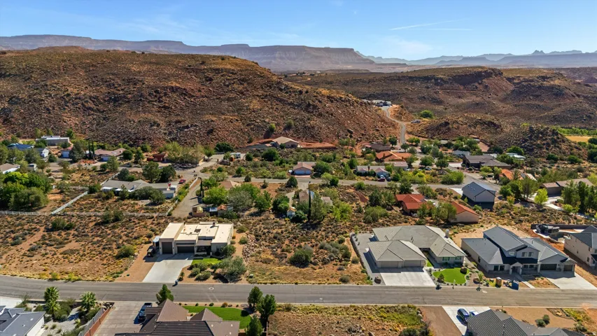 Expansive residential neighborhood with varied architectural styles situated against a dramatic mountain backdrop