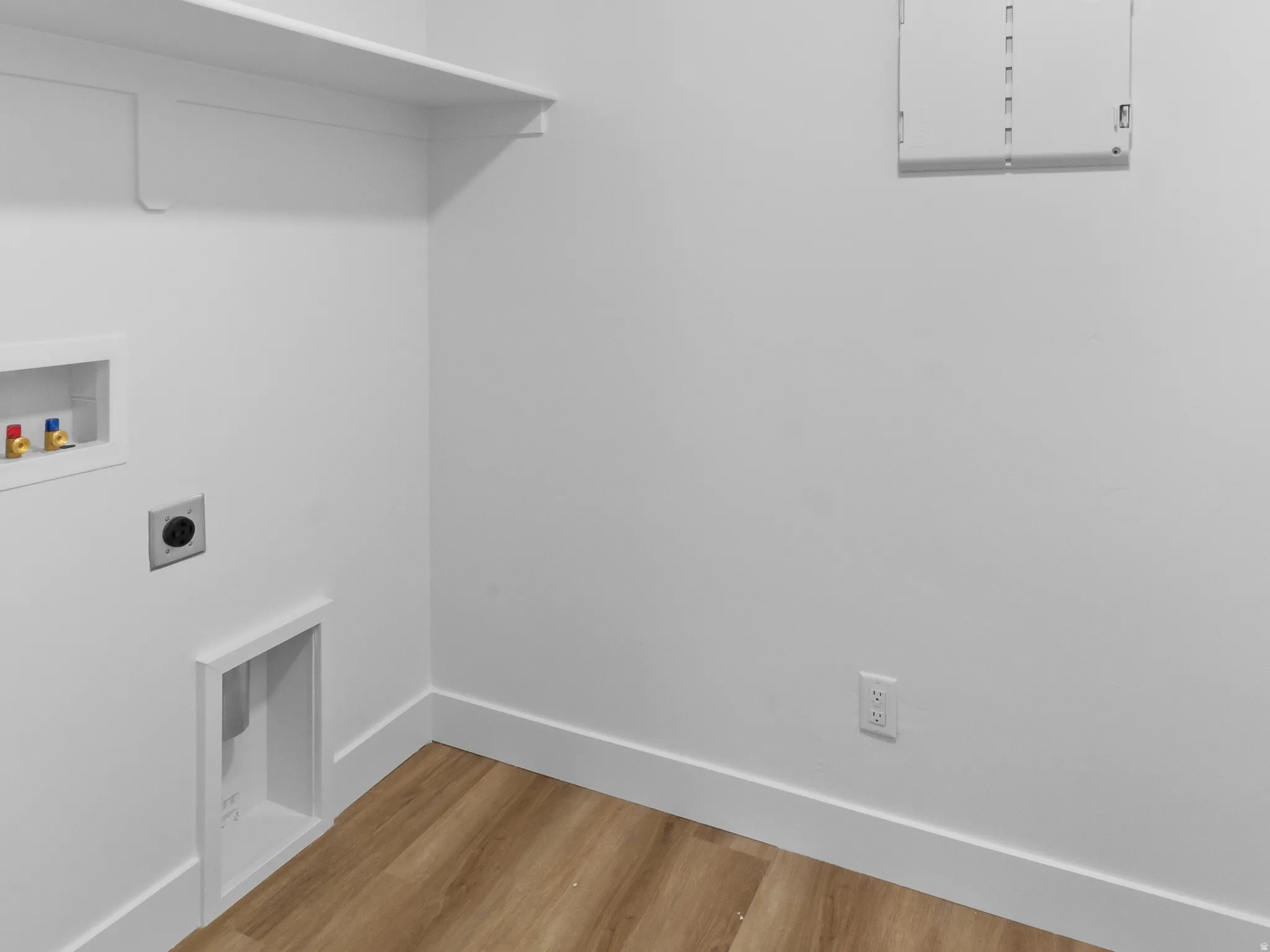 Light wood-finish flooring with white baseboards