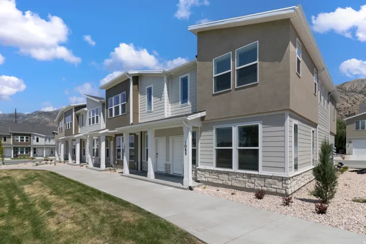 Contemporary exterior with a stone veneer foundation, horizontal siding, and stucco accents