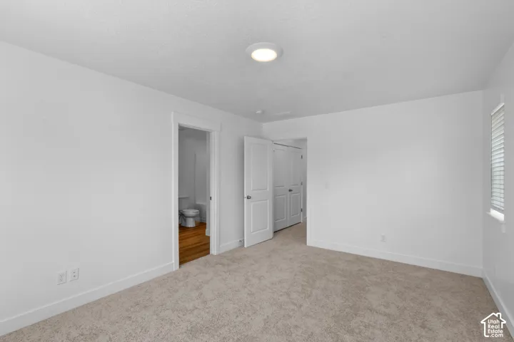 Plush carpeting, recessed lighting, white wall finishes, and white trim
