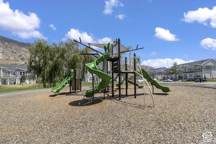 Community playground with multiple slides and climbing structures, surrounded by wood chip surfacing
