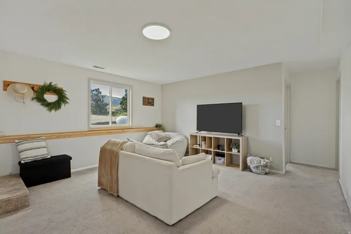 Carpeted flooring, recessed window with a mountain backdrop, light-toned walls, and a flush-mount ceiling light