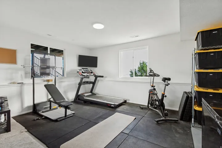 Recessed overhead lighting, two windows, and dark-toned rubber flooring