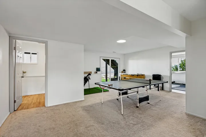 Carpeted entertainment area with recessed lighting, a sliding glass door, and an exterior patio