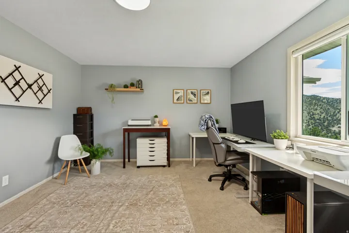 Neutral-toned walls complement the natural light from the large window, offering expansive mountain scenery