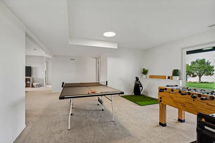 Carpeted recreation room with recessed lighting and a glass sliding door to the exterior