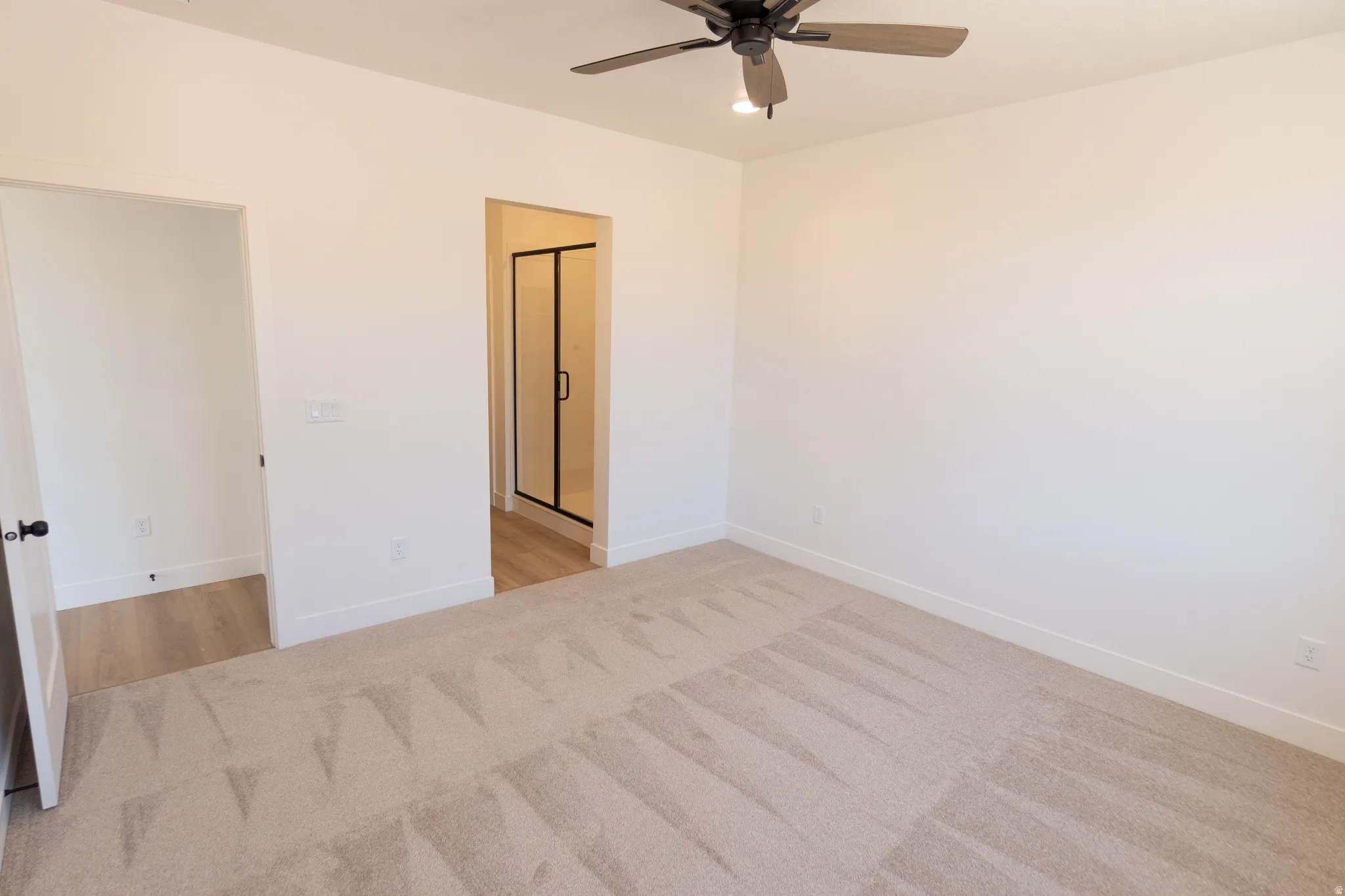 Plush carpeting, recessed lighting, and a contemporary ceiling fan