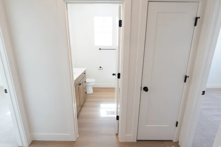 Bathroom featuring wood-finish flooring, a wood vanity with a white countertop, and a white toilet