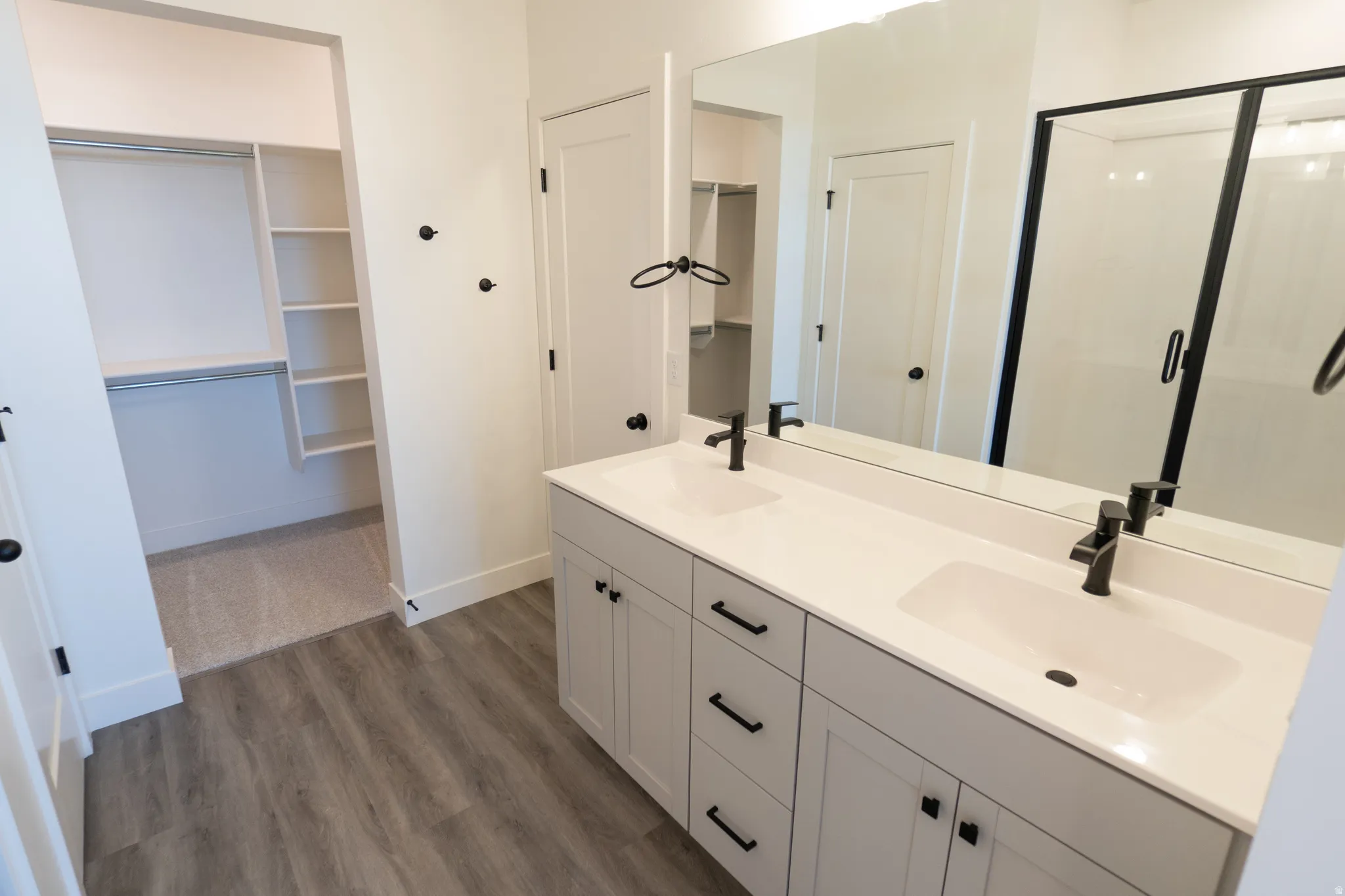 Dual vanity with white countertops, integrated sinks, and matte black fixtures