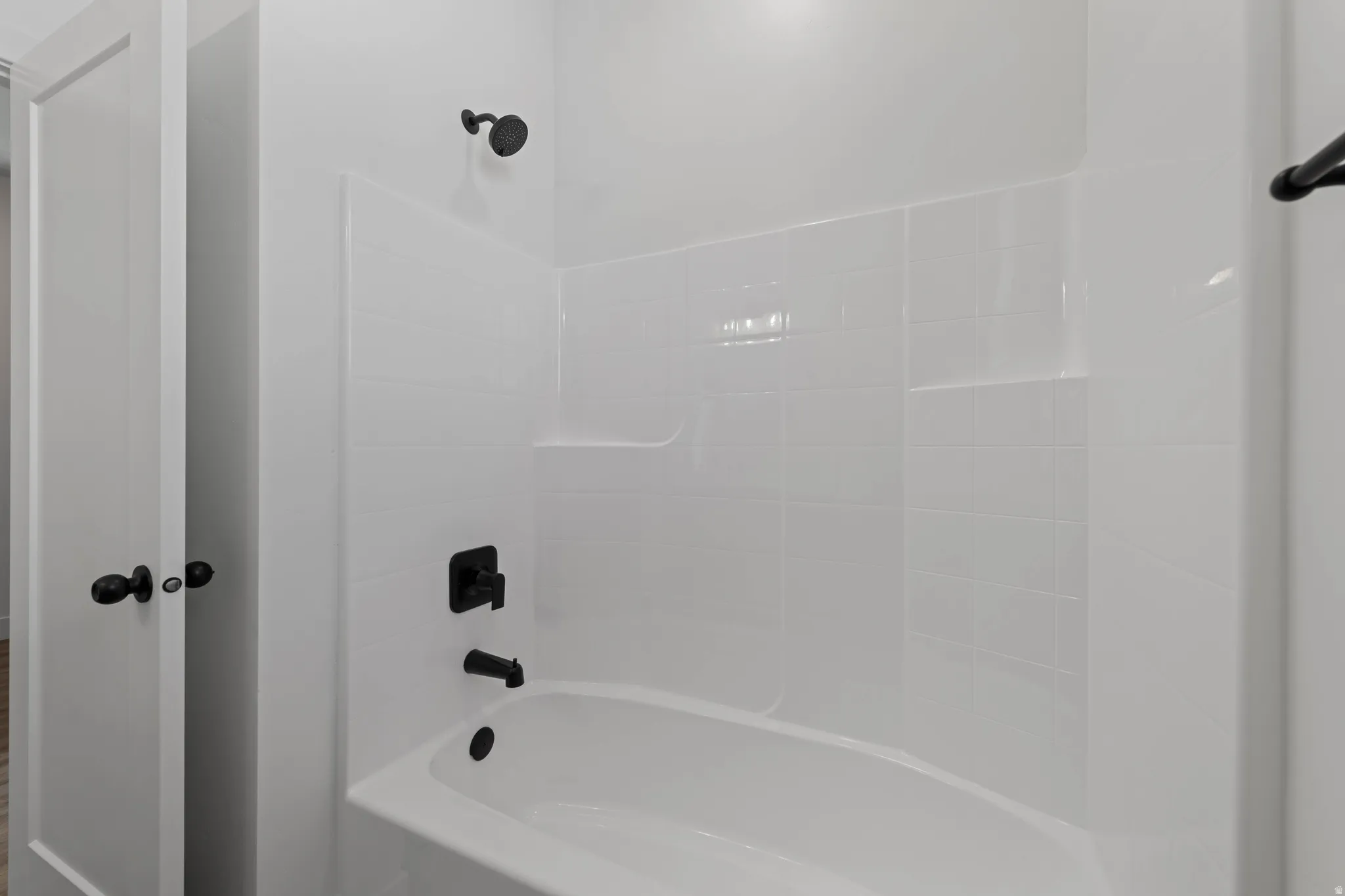 White subway tile shower surround with integrated shelving and matte black fixtures
