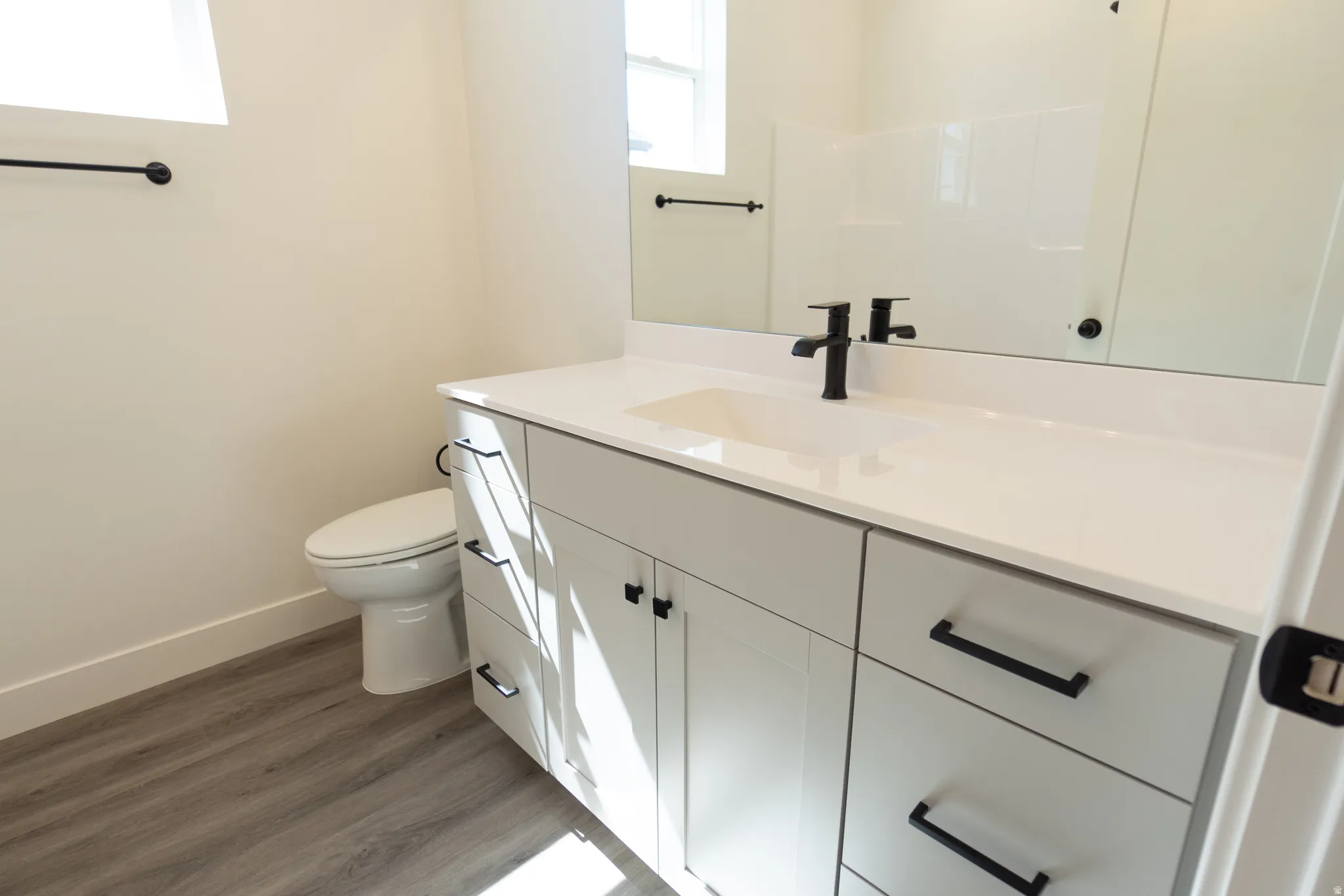White vanity with matte black hardware, integrated sink, and a single-handle faucet