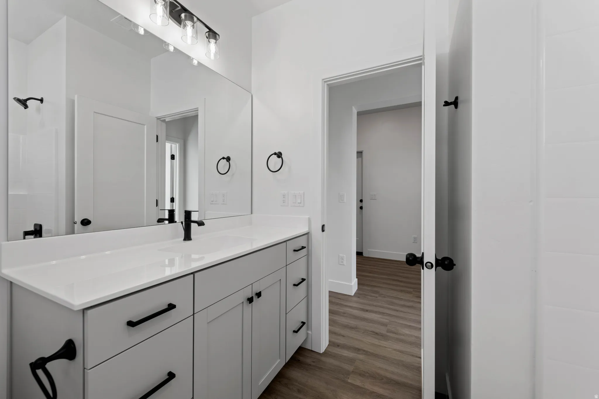 Vanity with a solid surface countertop, undermount sink, and matte black faucet