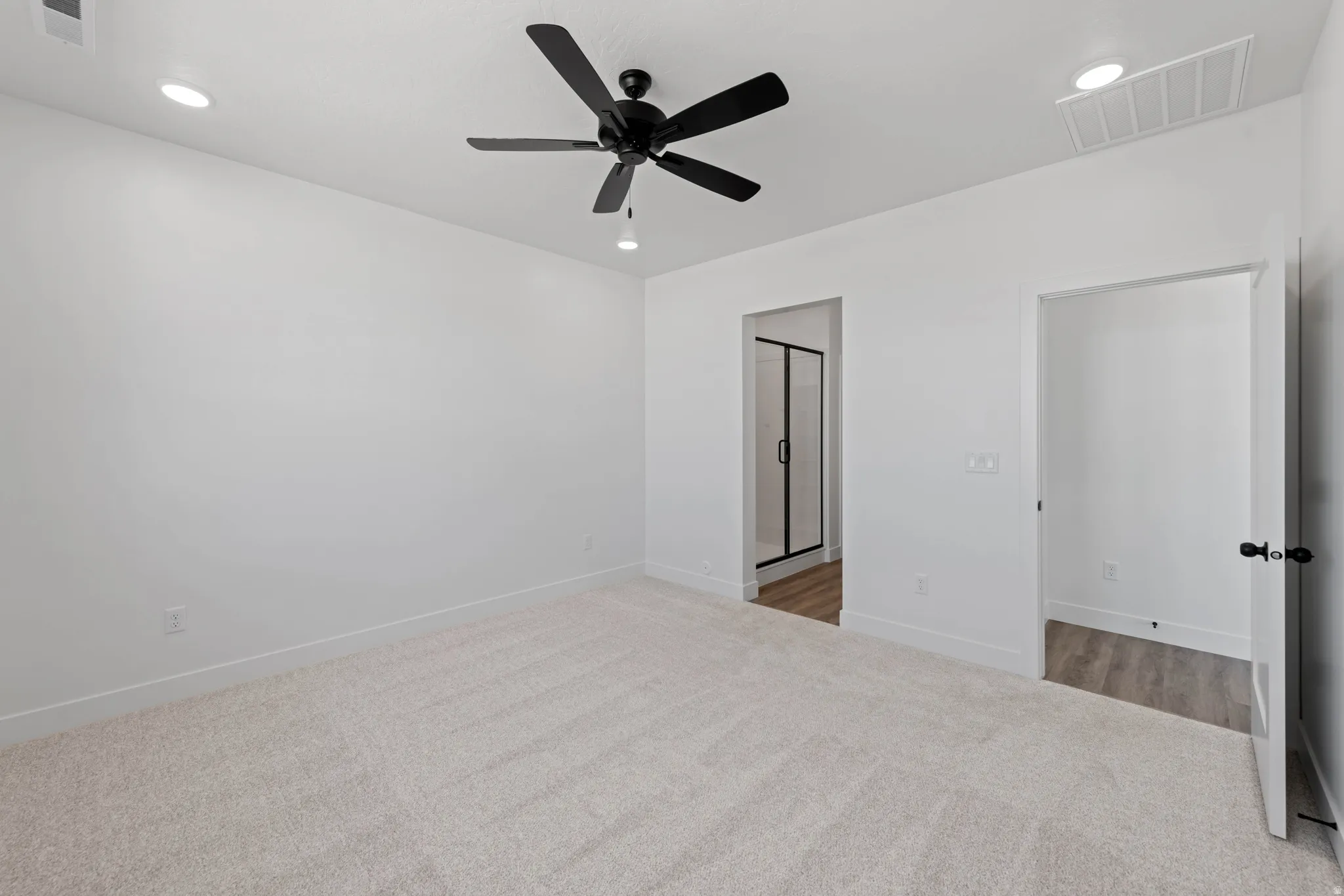 Plush carpet flooring with recessed ceiling lighting, a ceiling fan, and modern black door hardware