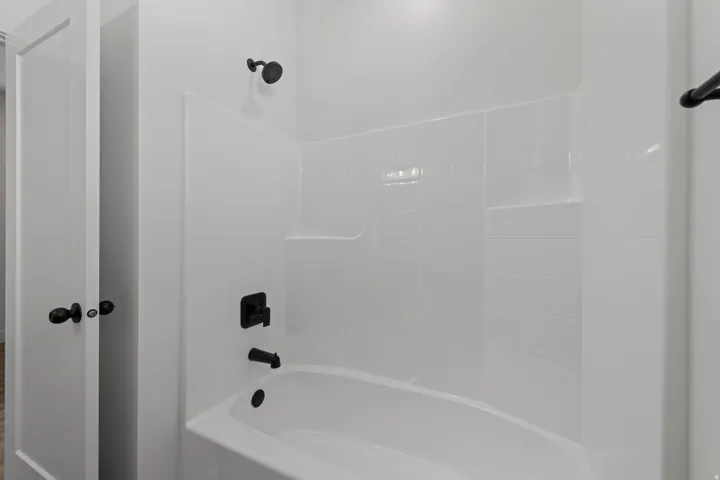 White subway tile shower surround with integrated shelving and matte black fixtures