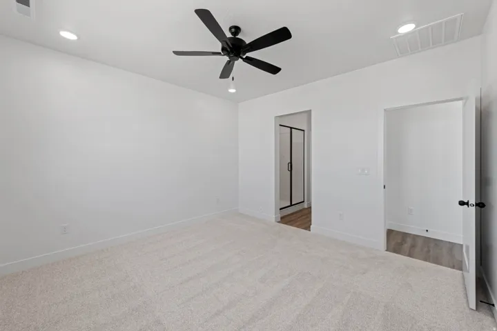 Plush carpet flooring with recessed ceiling lighting, a ceiling fan, and modern black door hardware