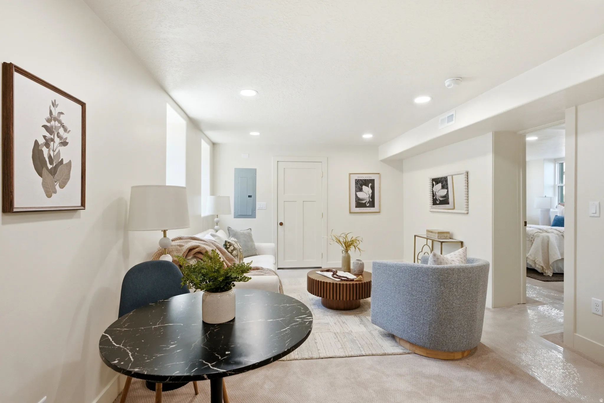 Recessed ceiling lighting, light neutral wall paint, and a white paneled door
