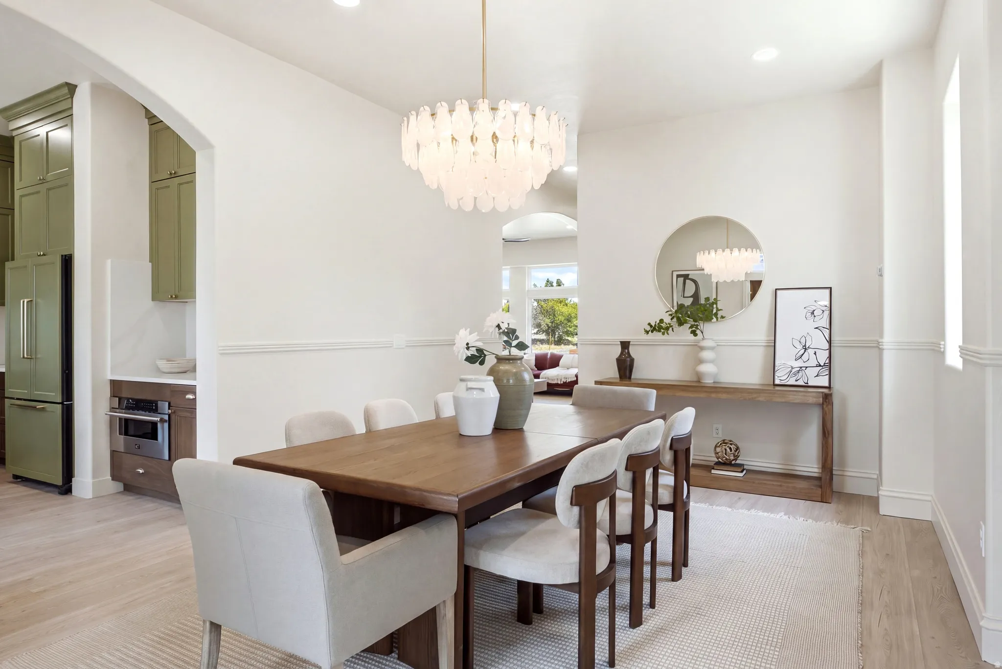 Open-concept dining area featuring wood-finish flooring, recessed lighting, and a decorative chandelier