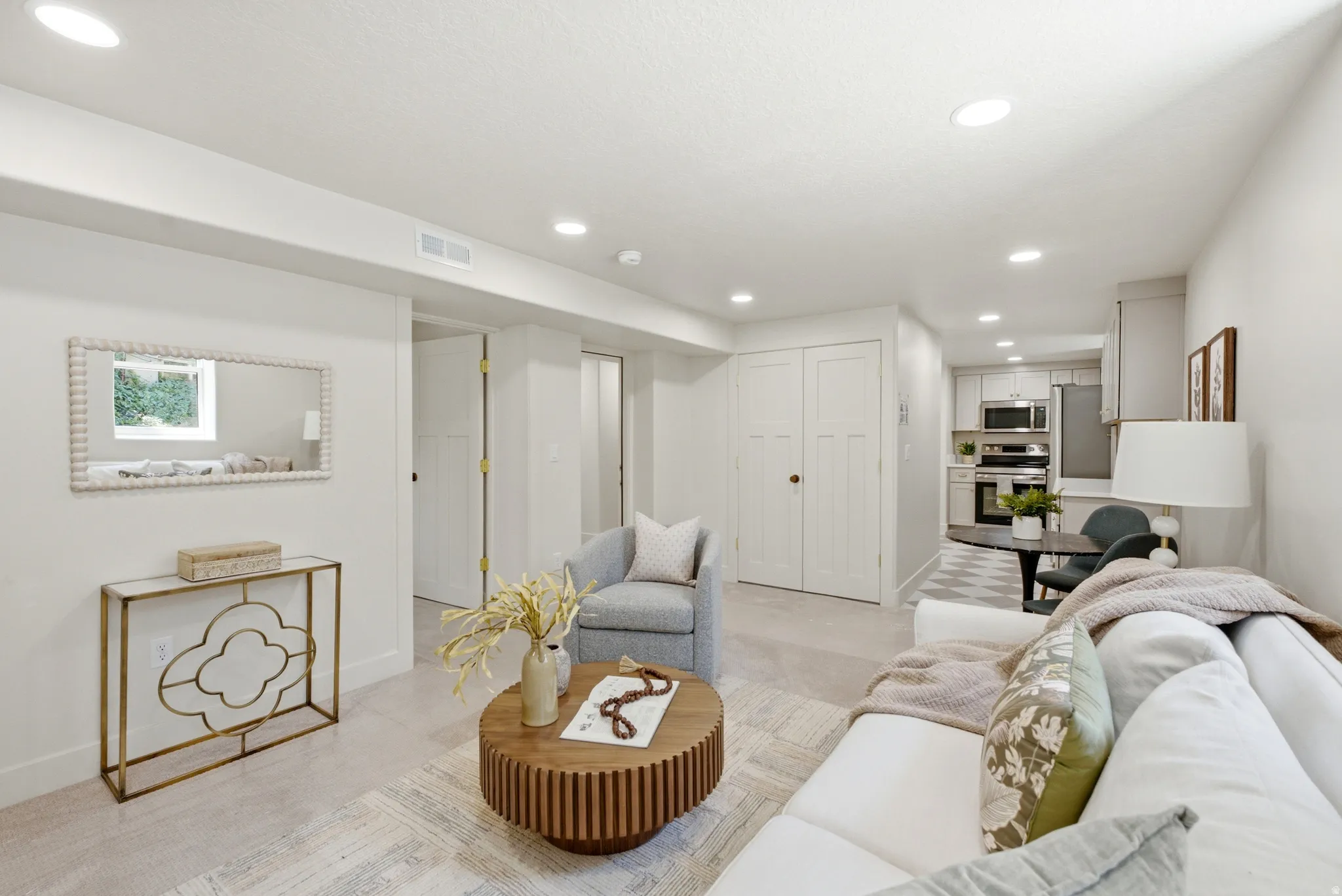Recessed lighting throughout, light-toned wall finishes, paneled interior doors, and a kitchen featuring stainless steel appliances and light-toned cabinetry