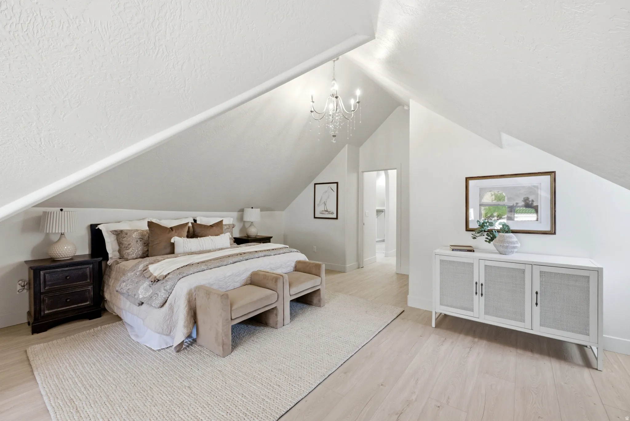 Vaulted ceilings, wood-finish flooring, and a crystal chandelier