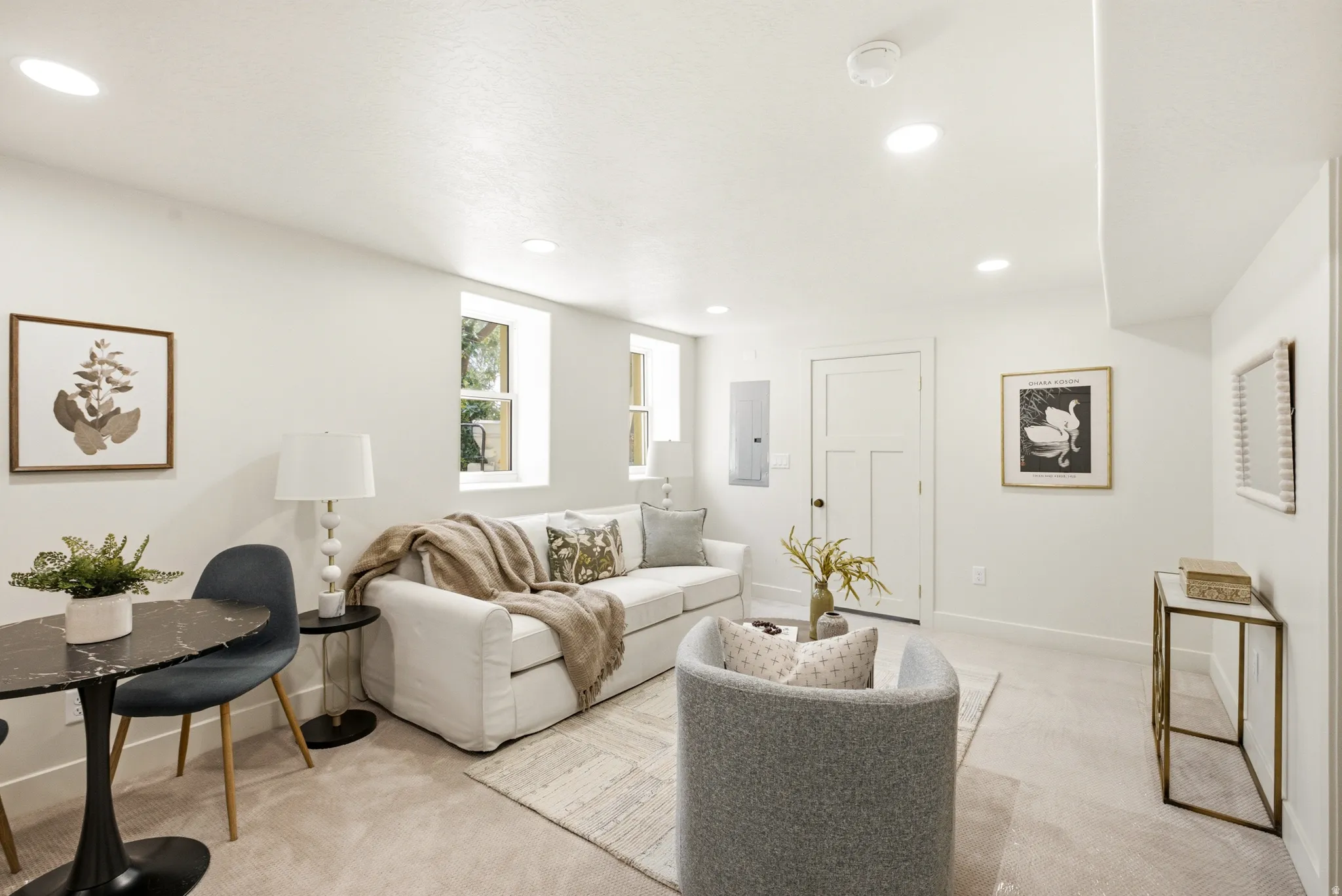 Recessed lighting illuminates the white walls and neutral carpet