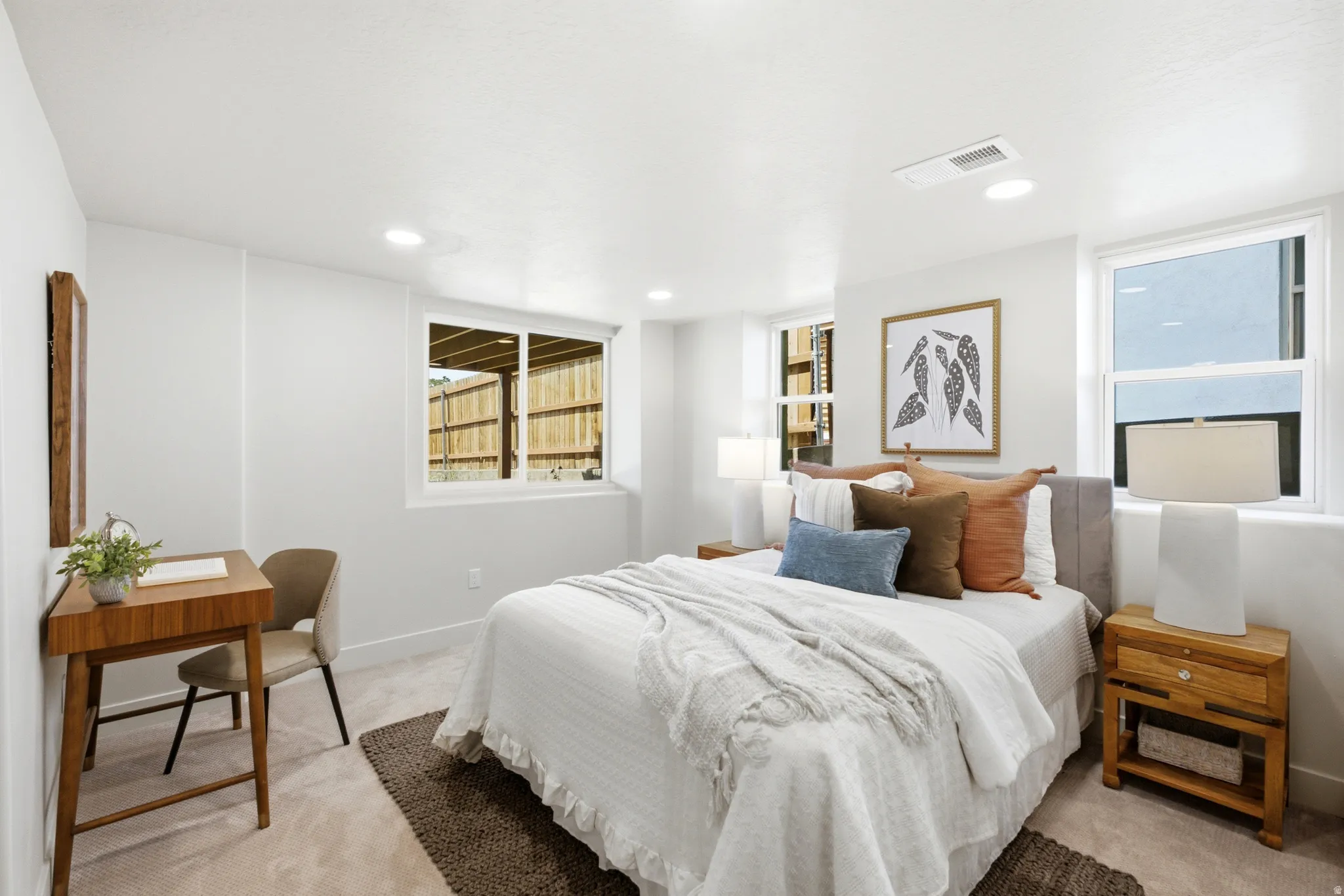 Recessed ceiling lighting, multiple egress windows, light neutral wall color, and carpeted flooring