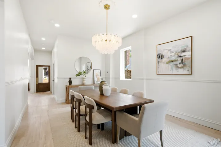 Recessed lighting, wood-finish flooring, wainscoting, and an ornate ceiling medallion with a chandelier