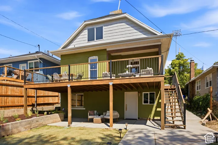 Modern home featuring a spacious covered deck with wood-beam construction, expansive lawn with mature landscaping, multi-level design with upper and lower living spaces, composite or wood-finish siding exterior, and integrated outdoor entertaining areas w