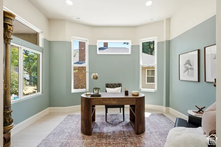 Recessed lighting, light wood-finish flooring, two-tone wall paint, multiple windows