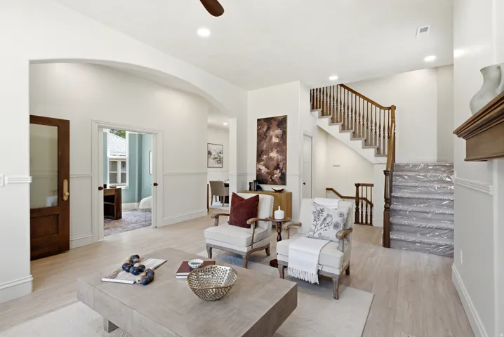 Hardwood-finish flooring, recessed lighting, arched entryway, wainscoting, and a detailed wooden staircase