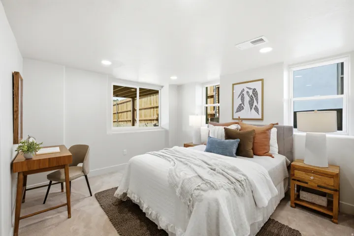Recessed ceiling lighting, multiple egress windows, light neutral wall color, and carpeted flooring
