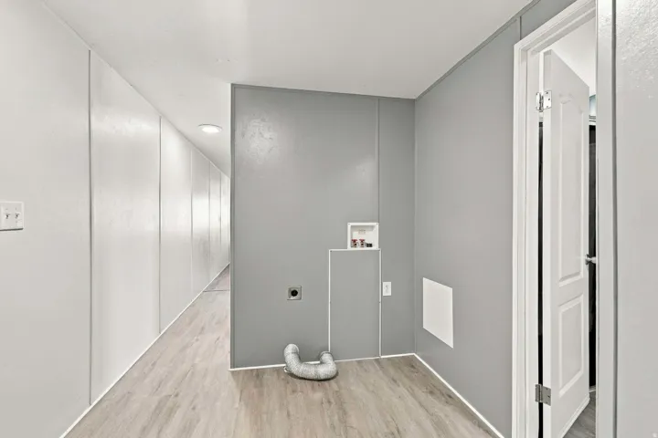 Utility area with wood-finish flooring, light gray and white paneled walls, and recessed lighting
