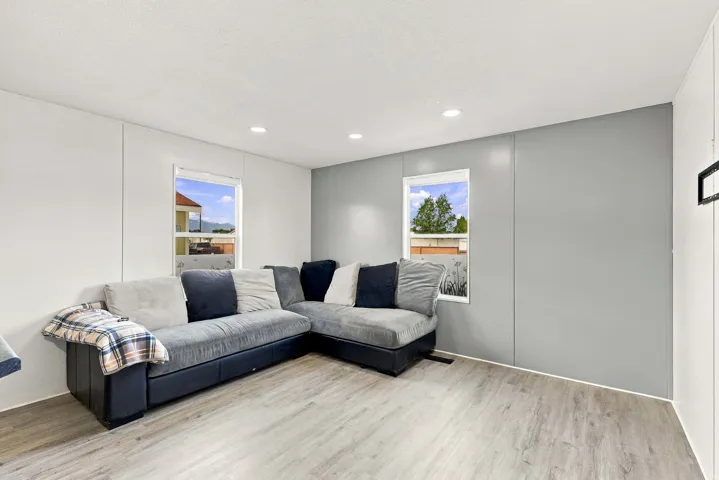 Recessed ceiling lighting, light wood-finish flooring, and white paneled walls