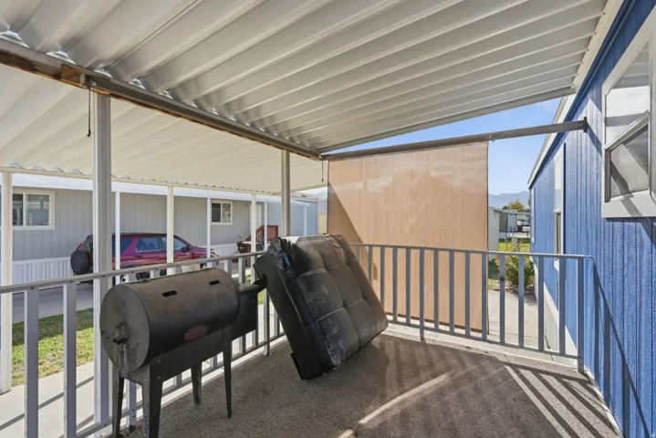 Covered patio with a privacy screen and metal railings