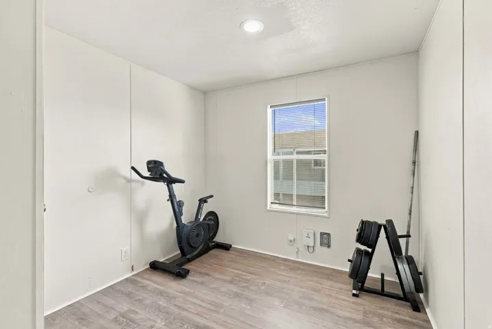 Recessed lighting, wood-finish flooring, and a window with blinds