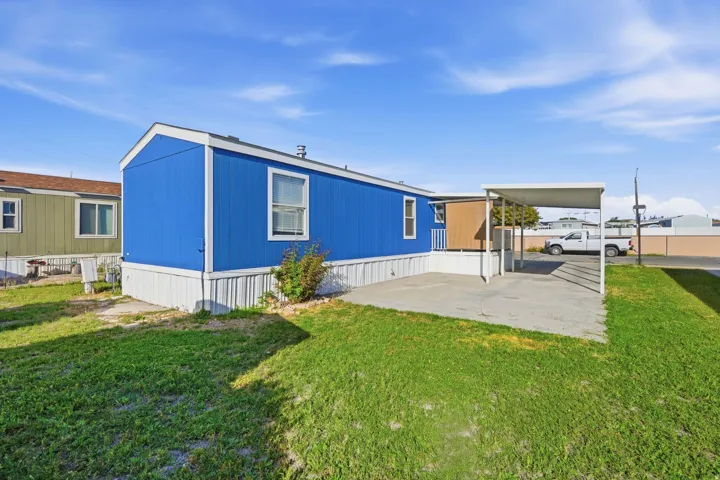 Single-story structure with blue siding, white trim, and a white foundation