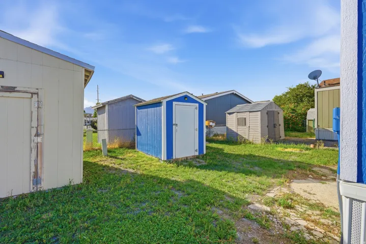 Multiple storage sheds on a grassy lot