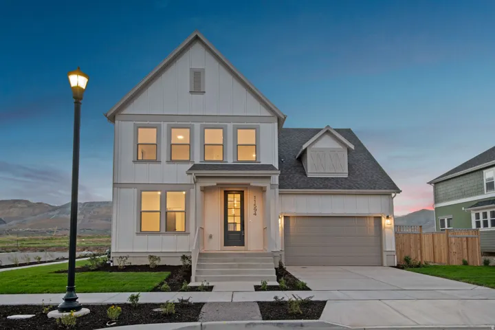 Contemporary two-story residence with a covered entryway, attached garage, and dormer window detail