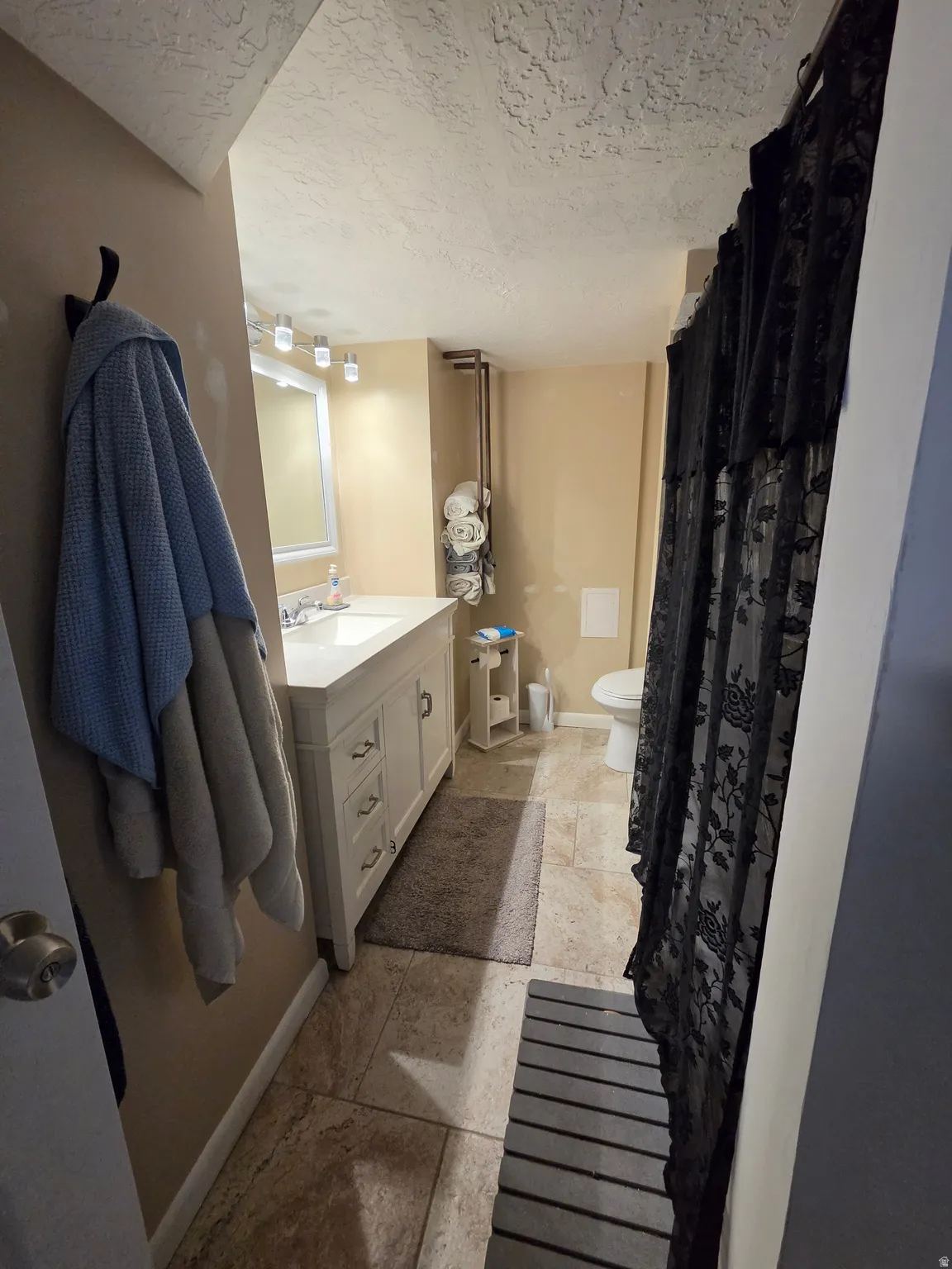 White vanity with brushed nickel hardware, integrated sink, and wall-mounted lighting