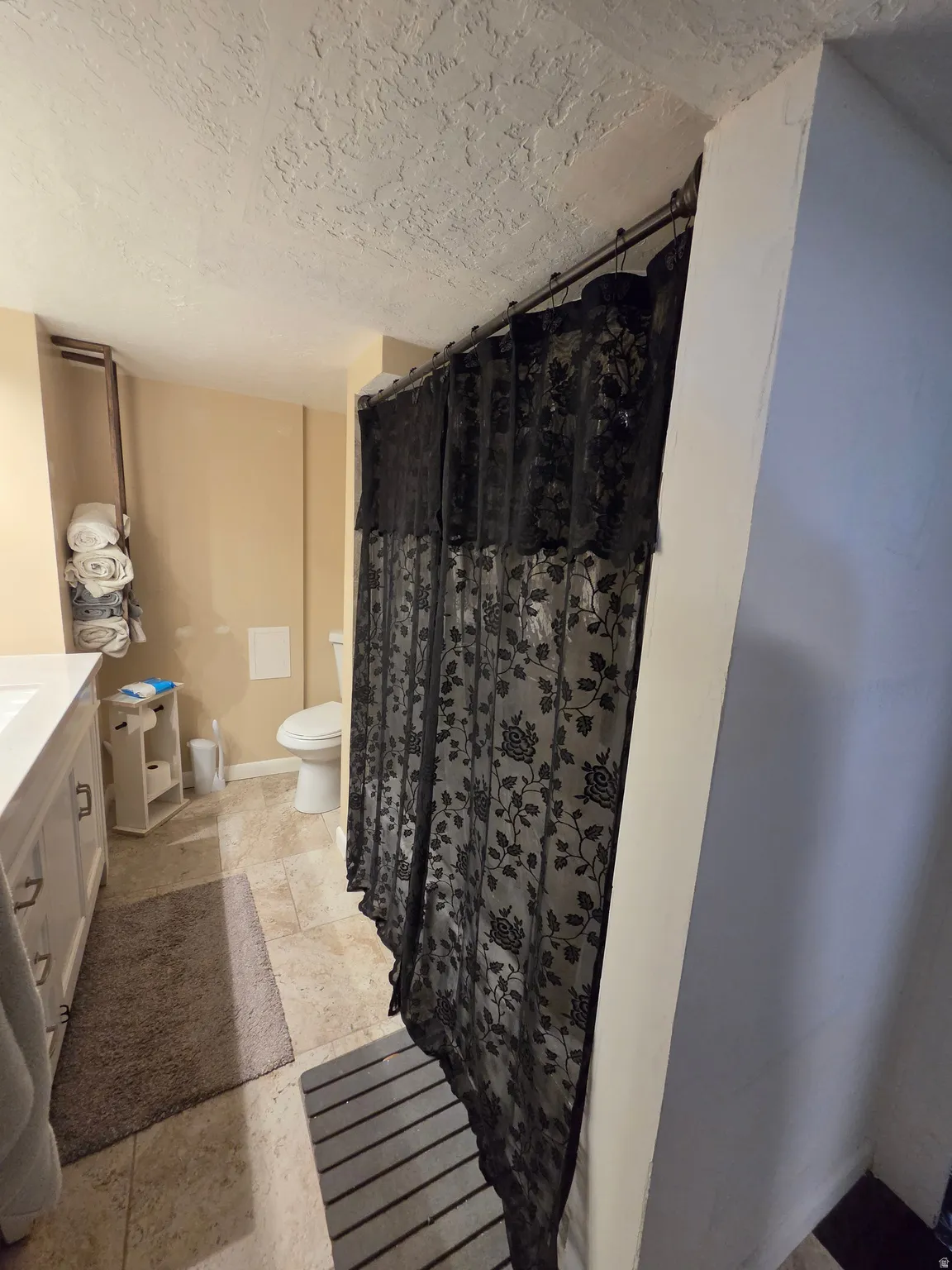 Bathroom featuring a single vanity with storage, tile flooring, and a white toilet