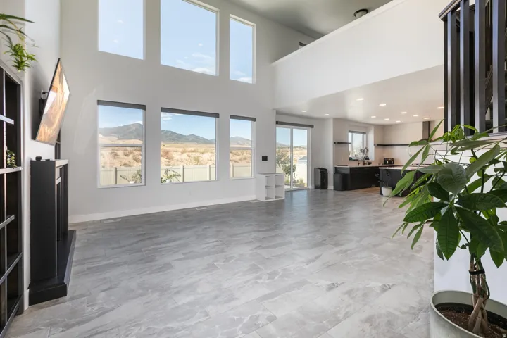 Two-story living area with high ceilings, large windows, and tile flooring