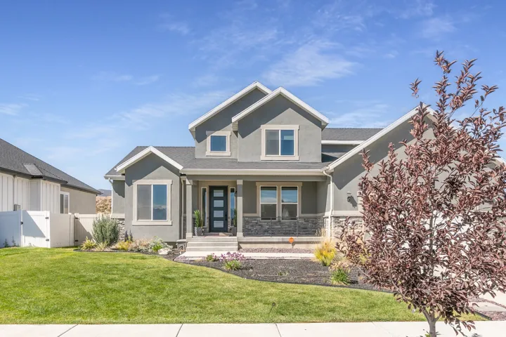 Contemporary stucco exterior with stone accents and a covered front porch