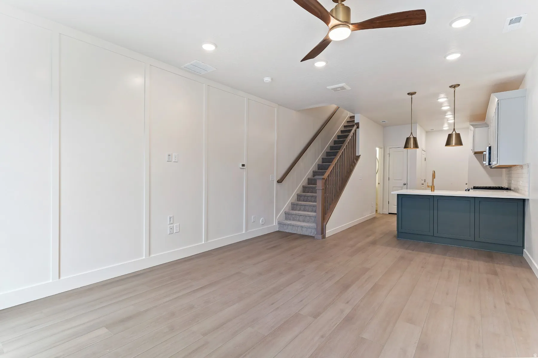 Open-concept living space featuring wood-finish flooring, recessed lighting, and a modern ceiling fan