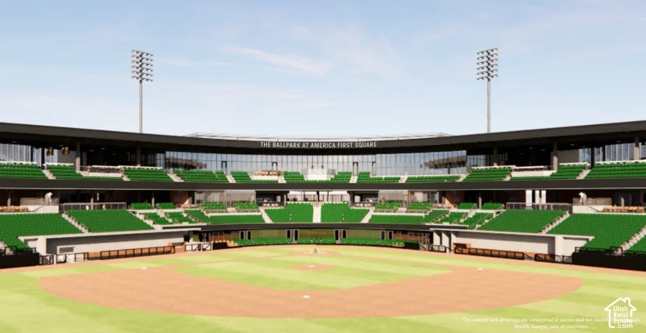 Green stadium seating, expansive baseball field, upper-level glass-fronted suites, prominent stadium lighting towers, and integrated signage