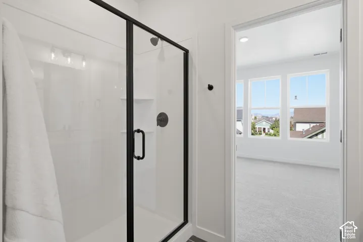 Primary bathroom featuring huge walk-in shower with clear glass enclosure and dark-finish hardware