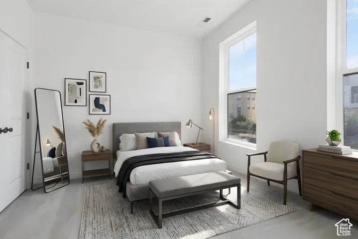 High ceilings, two large windows, light-toned walls, light-toned flooring, and a built-in door