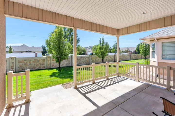 Covered back deck with vinyl railing and steps to back yard