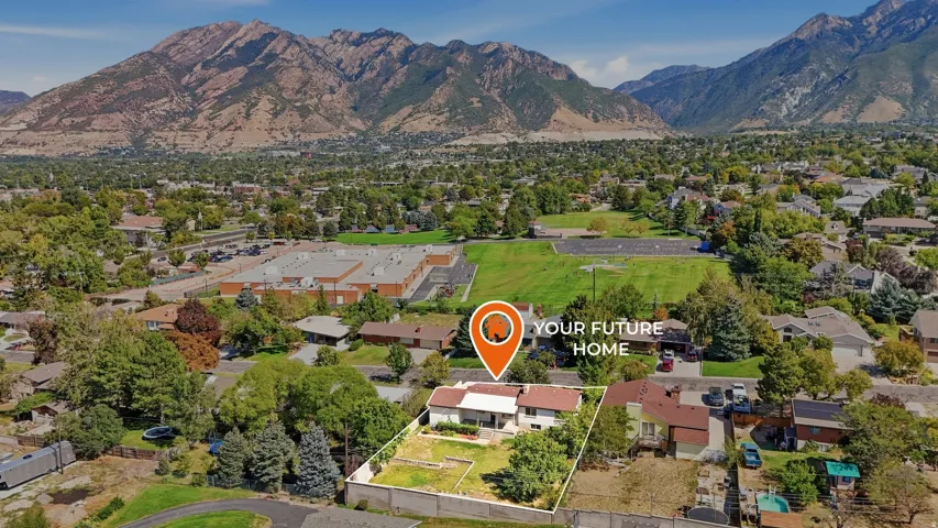 Expansive property with mature trees, a multi-level home, and a backdrop of mountain ranges