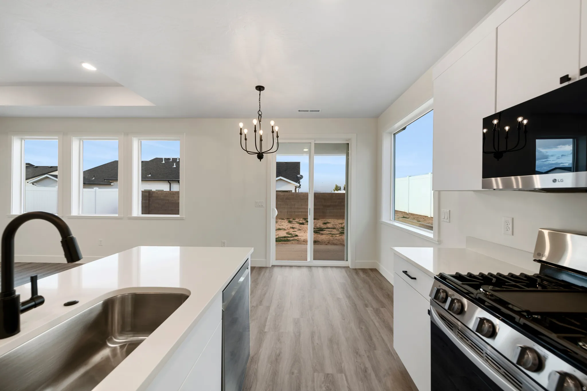 White cabinetry, stainless steel appliances, and a kitchen island with an undermount sink